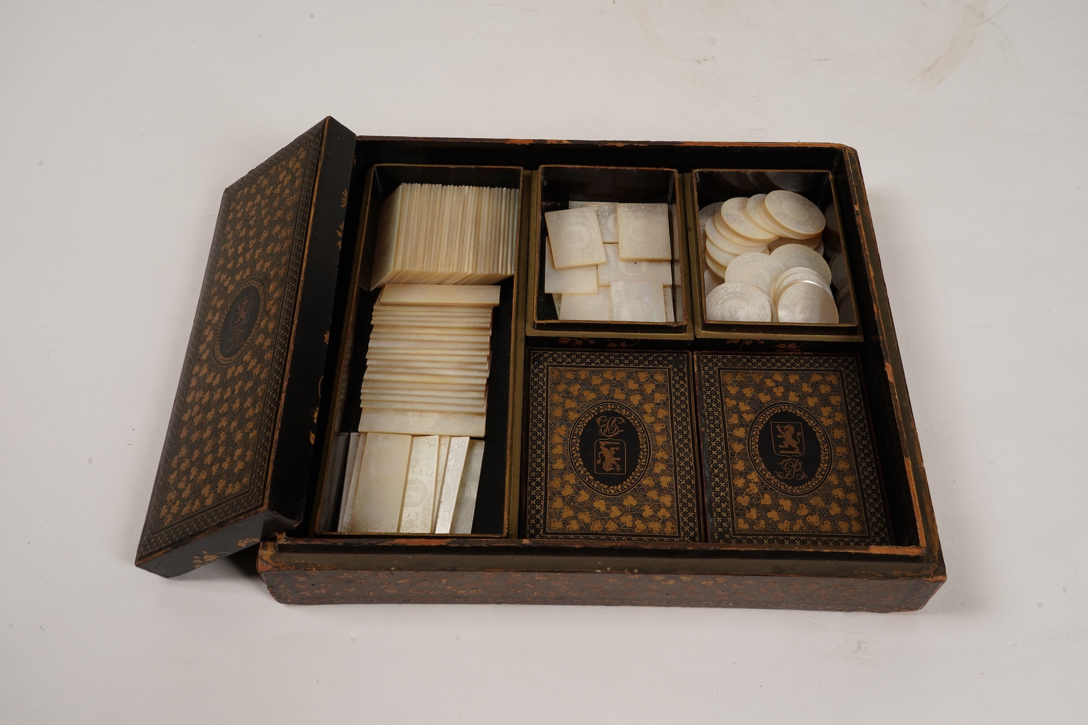 Two Chinese gilt decorated black lacquer games boxes, containing numerous mother-of-pearl counters, 19th century